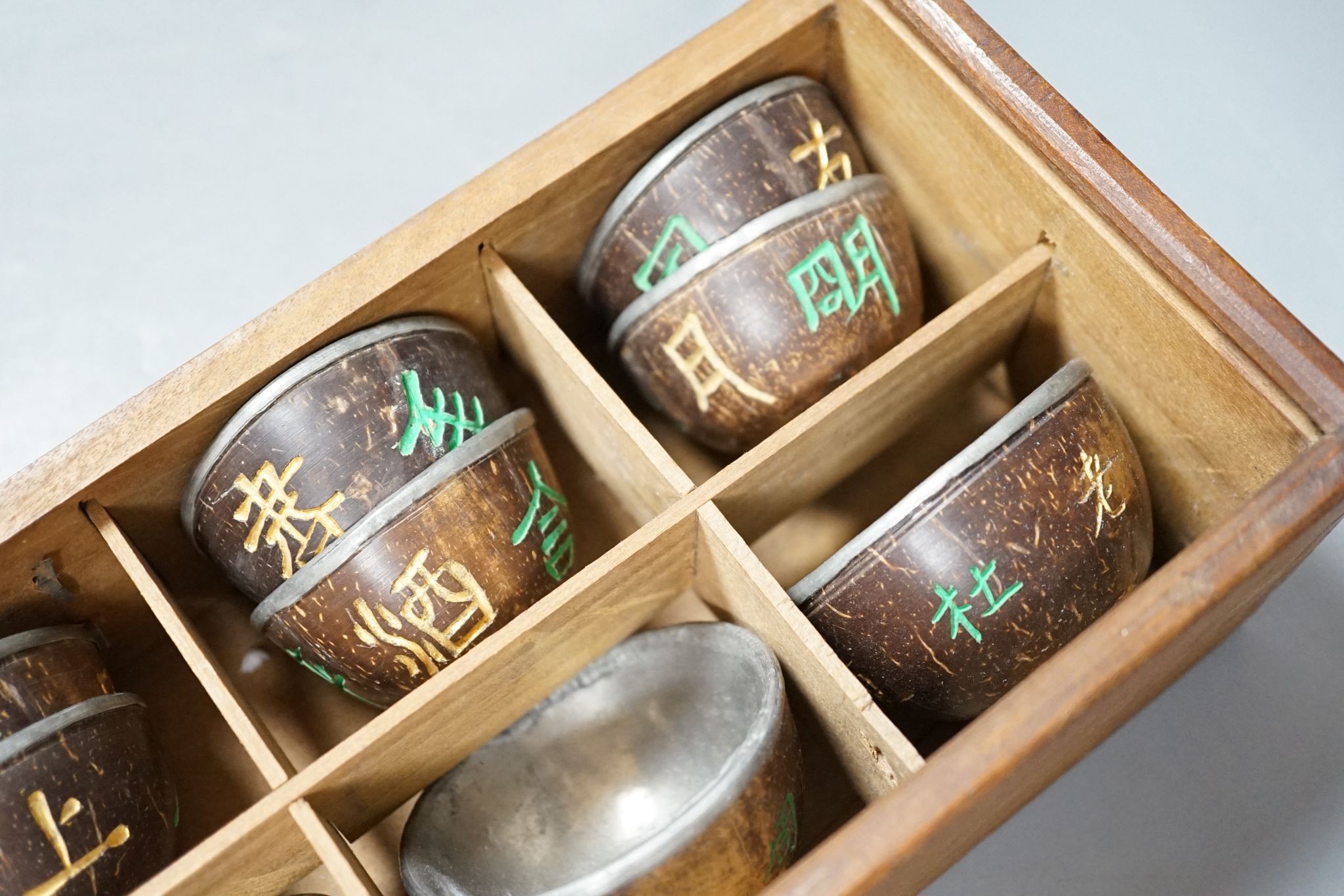 An early 20th century Chinese cased set of coconut cups with pewter liners